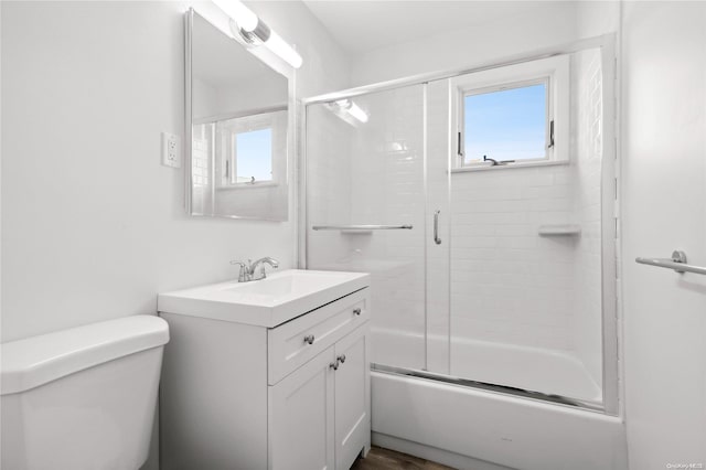 full bathroom featuring hardwood / wood-style floors, vanity, toilet, and enclosed tub / shower combo