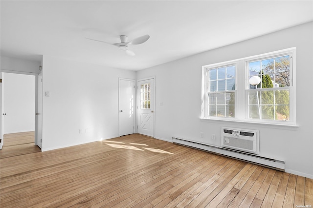 empty room with ceiling fan, a baseboard heating unit, a wall mounted AC, and light hardwood / wood-style flooring