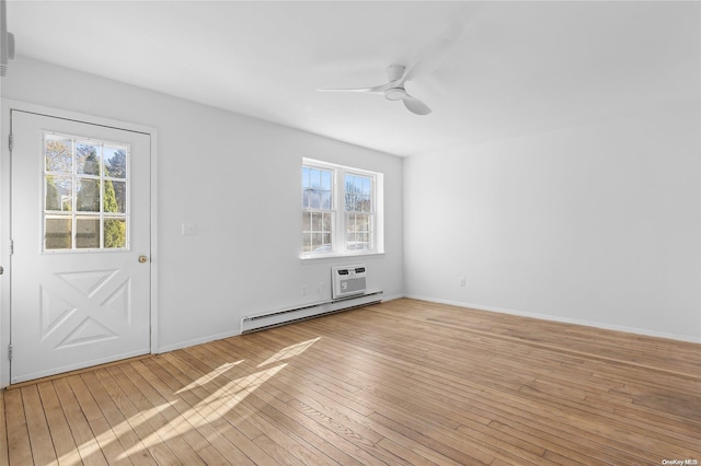 spare room with light hardwood / wood-style floors, ceiling fan, a healthy amount of sunlight, and a baseboard heating unit