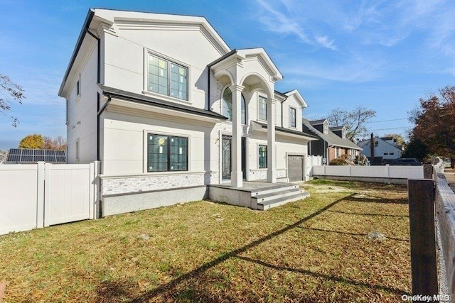 rear view of property featuring a yard and a garage