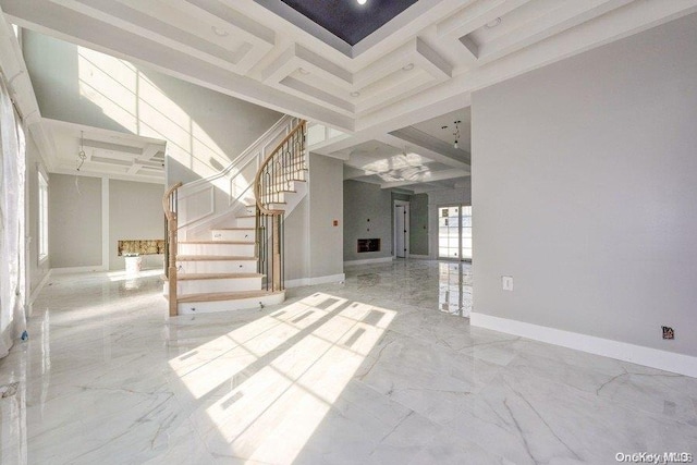 unfurnished living room with beam ceiling, a towering ceiling, and coffered ceiling