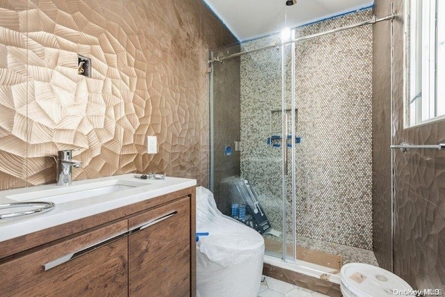 bathroom featuring tile patterned flooring, vanity, and a shower with door