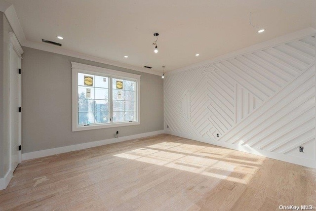 empty room with light hardwood / wood-style flooring and crown molding