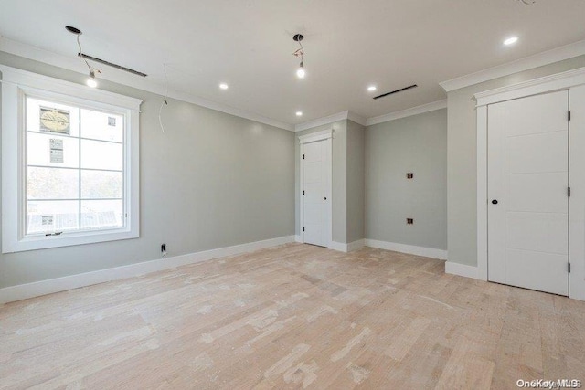 spare room featuring light wood-type flooring and crown molding