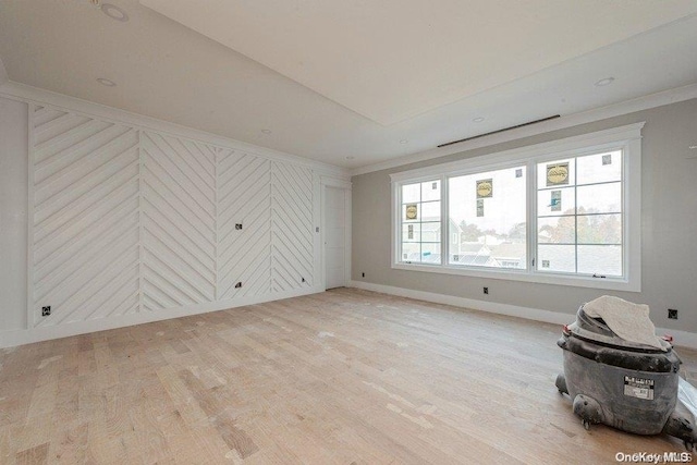 unfurnished room featuring ornamental molding and light hardwood / wood-style flooring