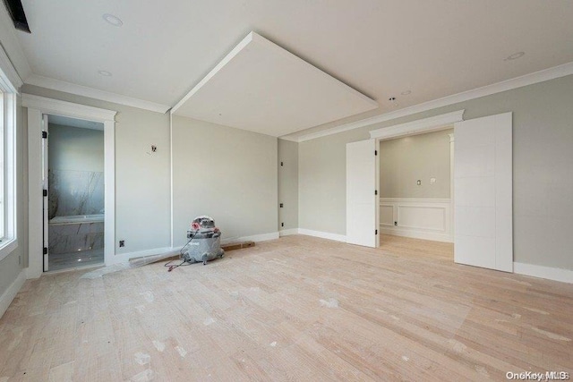 spare room with crown molding and light hardwood / wood-style flooring