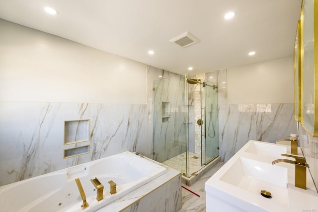 bathroom with tile walls, independent shower and bath, and vanity