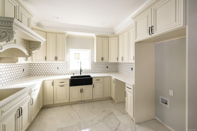 kitchen with ornamental molding, sink, cream cabinetry, and backsplash