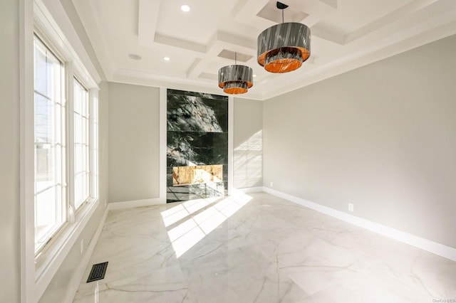 unfurnished room with coffered ceiling, a wealth of natural light, and beam ceiling