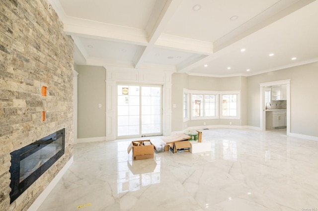 unfurnished living room featuring a large fireplace, ornamental molding, beamed ceiling, and coffered ceiling