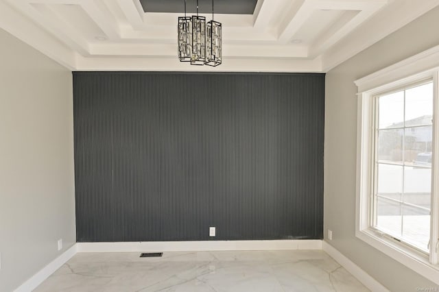 spare room with a notable chandelier and a tray ceiling