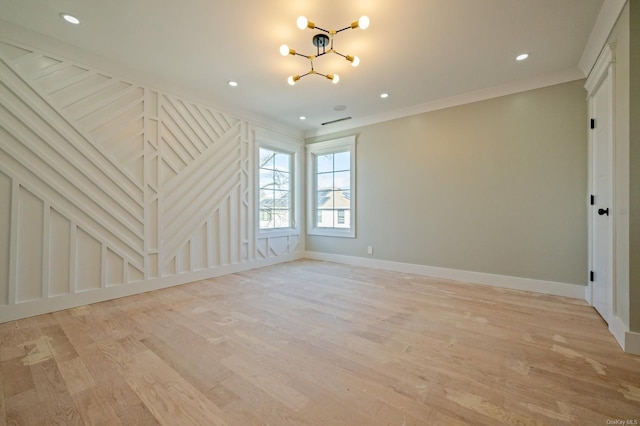 empty room with light wood-type flooring, crown molding, and a notable chandelier