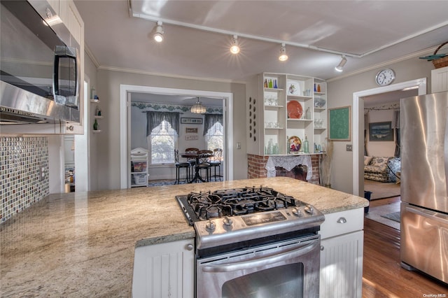 107 Jessup Ave, Quogue, NY 11959 - kitchen featuring stainless steel appliances, rail lighting, white cabinetry, ornamental molding, and dark wood-style floors