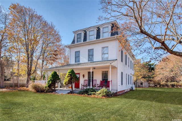 107 Jessup Ave, Quogue, NY 11959 - second empire-style home featuring mansard roof, a porch, and a front yard