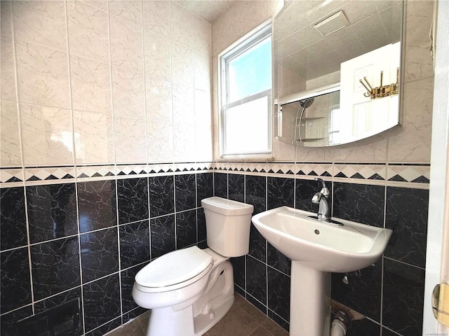 bathroom with walk in shower, sink, tile walls, and toilet