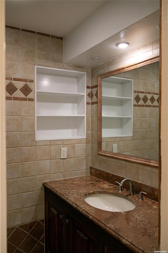 bathroom with decorative backsplash, vanity, and tile walls