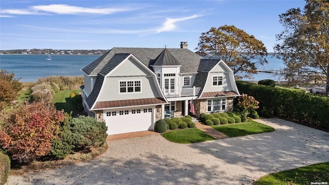 view of front of home with a water view, a balcony, and a garage