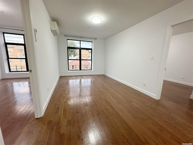 unfurnished room with dark hardwood / wood-style flooring and a wall mounted air conditioner