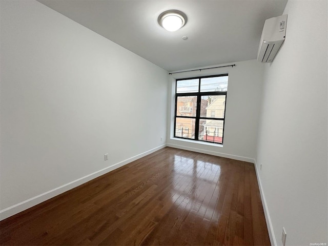 empty room featuring an AC wall unit and dark hardwood / wood-style floors