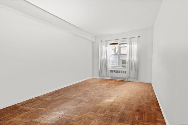 spare room with parquet floors and radiator