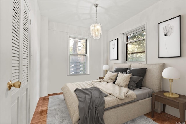 bedroom featuring an inviting chandelier and multiple windows