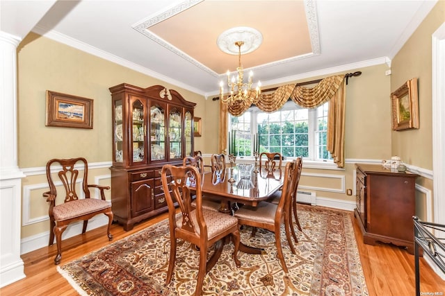 dining space featuring light hardwood / wood-style flooring, an inviting chandelier, and ornamental molding