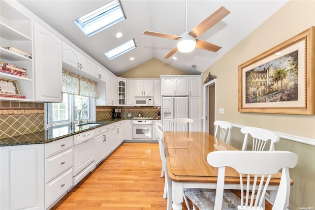 kitchen with white cabinetry, white appliances, sink, and light hardwood / wood-style flooring