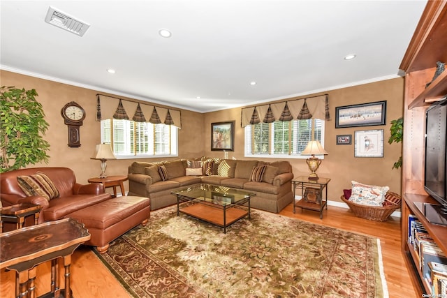 living room with hardwood / wood-style floors and crown molding