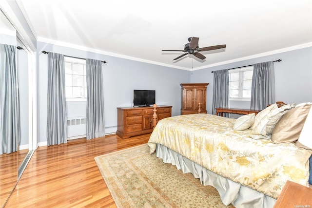 bedroom featuring hardwood / wood-style flooring, ceiling fan, crown molding, and a baseboard radiator