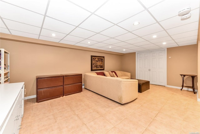 tiled living room with a paneled ceiling