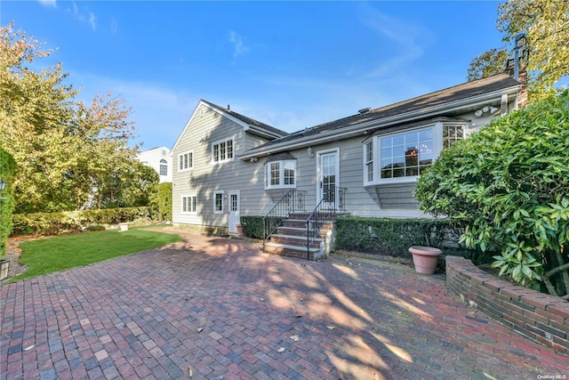 rear view of property with a patio and a lawn