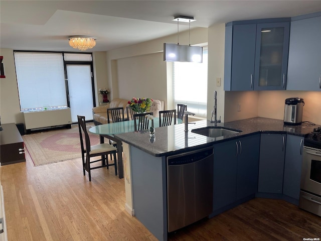 kitchen with pendant lighting, blue cabinets, sink, and appliances with stainless steel finishes