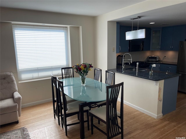 dining area with sink and light hardwood / wood-style flooring