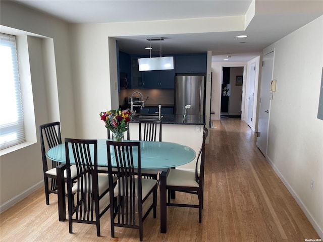 dining room with hardwood / wood-style floors and sink