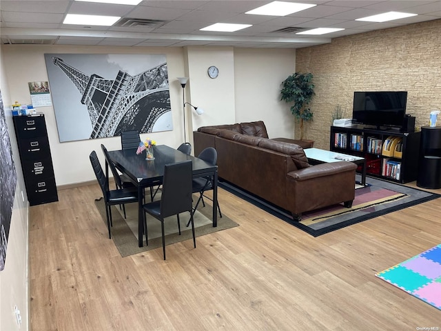 living room with a drop ceiling and light hardwood / wood-style floors