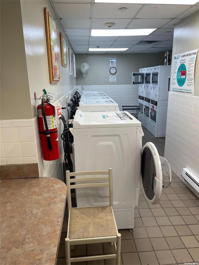 washroom featuring tile patterned flooring, washer and dryer, and a baseboard radiator