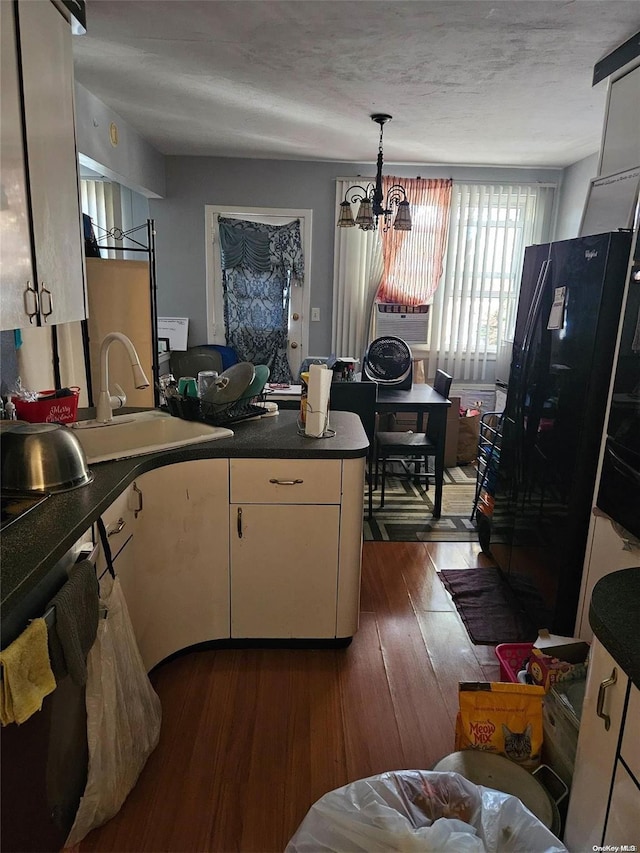 1258 E 56th St, Brooklyn, NY 11234 - kitchen featuring a peninsula, freestanding refrigerator, a chandelier, dark wood-style flooring, and dark countertops