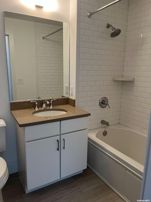 full bathroom featuring tiled shower / bath, toilet, vanity, and hardwood / wood-style flooring