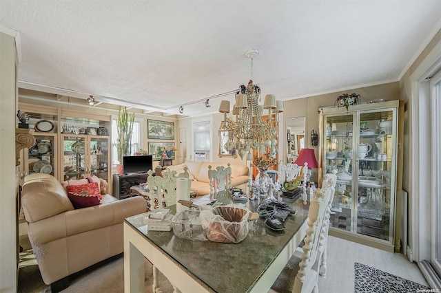 dining area with rail lighting, a chandelier, a textured ceiling, and ornamental molding