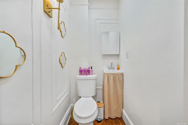 bathroom featuring wood-type flooring, toilet, and sink