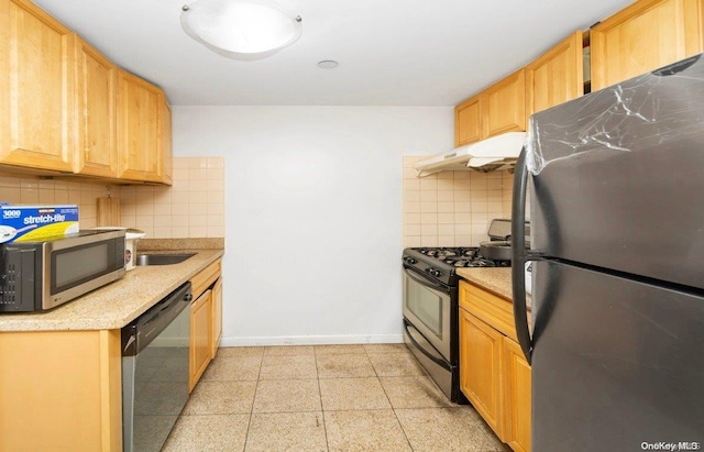 kitchen with backsplash, light brown cabinets, and appliances with stainless steel finishes