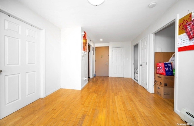 hallway featuring light hardwood / wood-style flooring and a baseboard heating unit