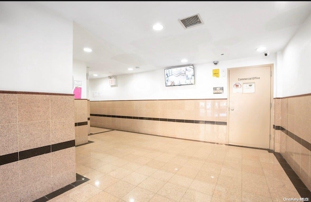 136-16 35th Ave Unit 7C, Flushing, NY 11354 - reception area with wainscoting, recessed lighting, tile walls, and a surveillance system