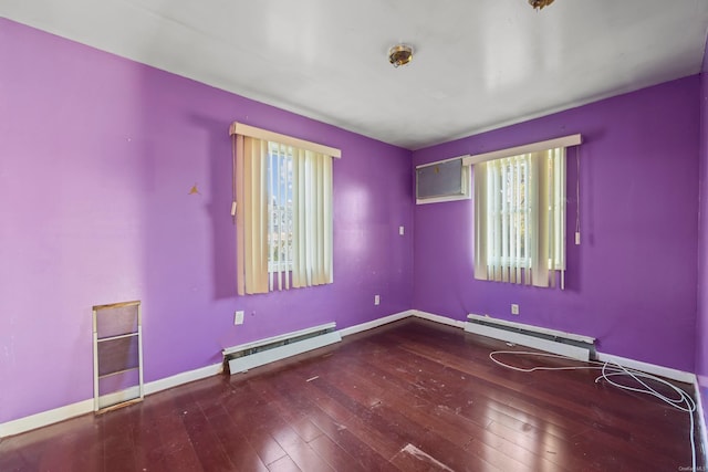 empty room with wood-type flooring, a healthy amount of sunlight, and a baseboard heating unit