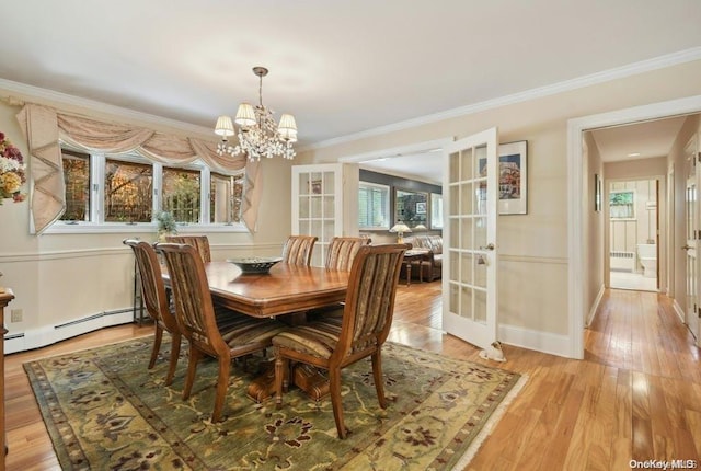 dining space featuring an inviting chandelier, french doors, ornamental molding, light wood-type flooring, and baseboard heating