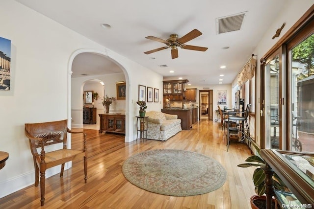 living room with ceiling fan and light hardwood / wood-style flooring