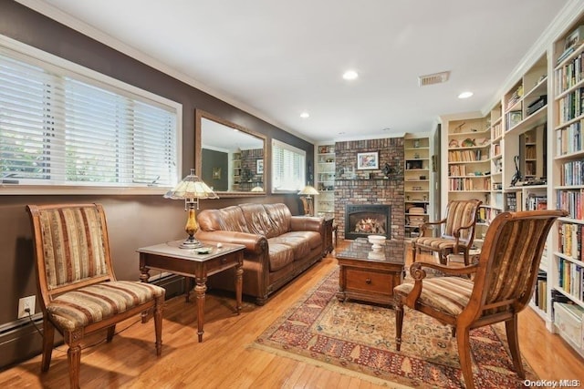 sitting room with crown molding, a fireplace, and light wood-type flooring