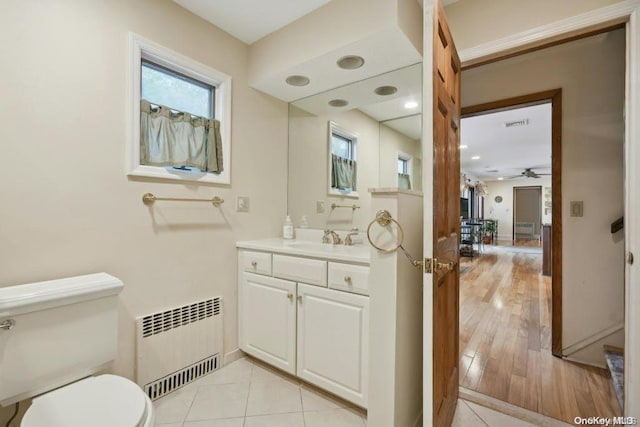 bathroom featuring radiator, ceiling fan, toilet, vanity, and hardwood / wood-style flooring