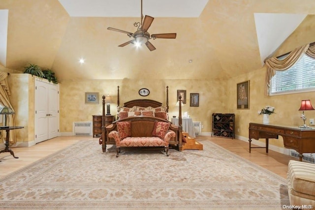 bedroom featuring ceiling fan, light wood-type flooring, radiator heating unit, and vaulted ceiling