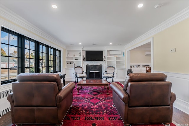 living room featuring built in shelves, dark hardwood / wood-style flooring, ornamental molding, and radiator